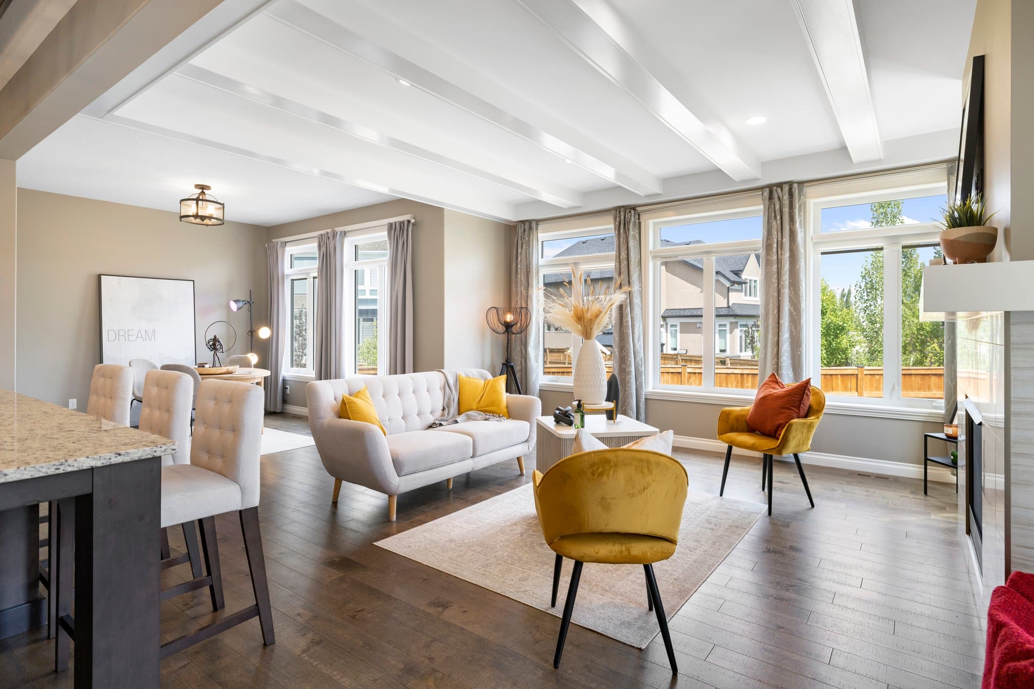 Bright, showing-ready open-plan living room with large windows and carefully arranged furniture.